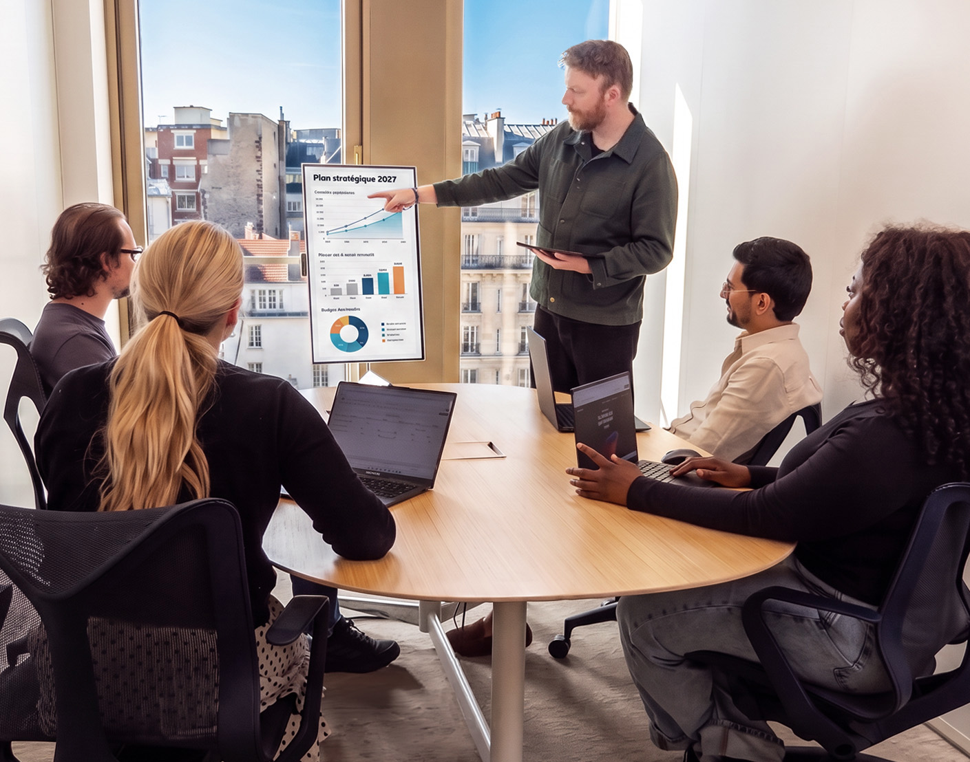 Écran mobile UNOWHY utilisé en réunion d'équipe pour présenter un plan stratégique, collaboration autour d'un même contenu