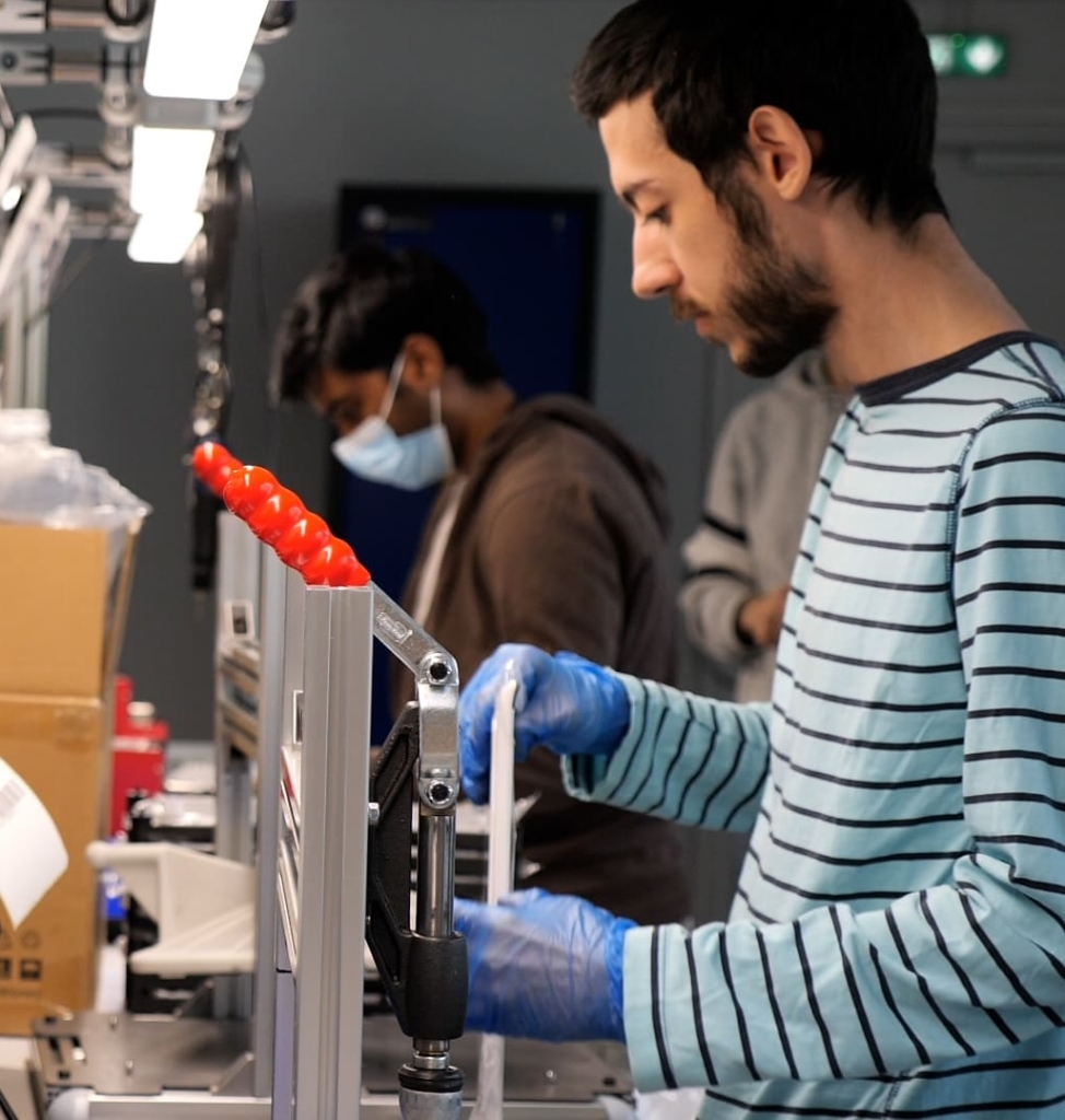 Ligne d'assemblage de la Fabrique UNOWHY à Neuilly-sur-Seine, techniciens assemblant des équipements informatiques